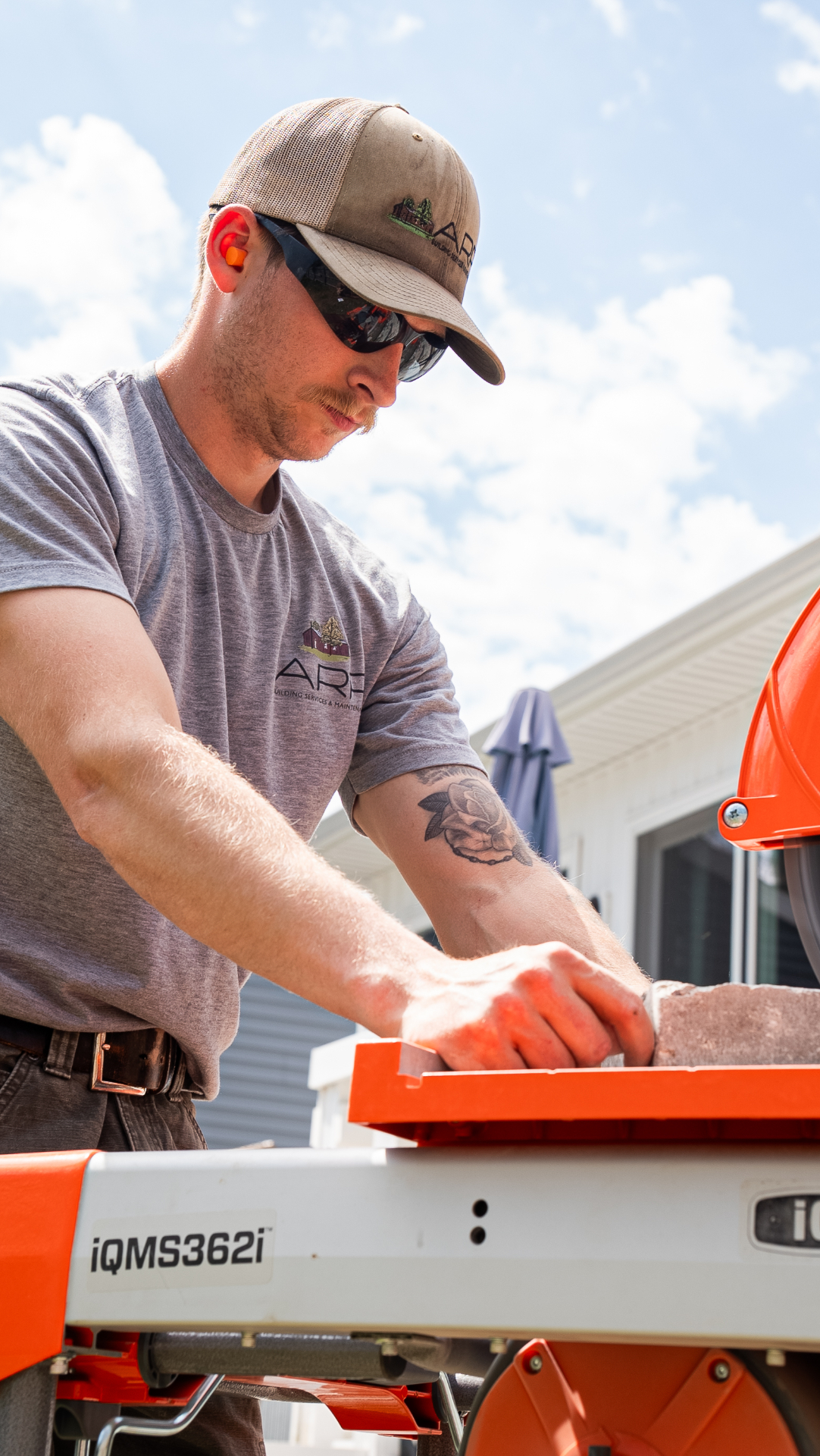 Crew Member Cutting Pavers at the Saw Station